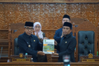  Bupati Kutim, Ardiansyah memegang dokumen KUA PPAS bersama Ketua DPRD Kutim, Jimmi di Ruang Sidang Utama Kantor DPRD, pada Jumat (18/09/26). (Pemkab Kutim)